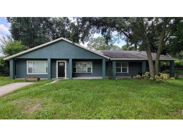Charming single-story home with a well-maintained lawn and freshly painted exterior with neutral trim at 8013 N Ola Ave, Tampa, FL 33604