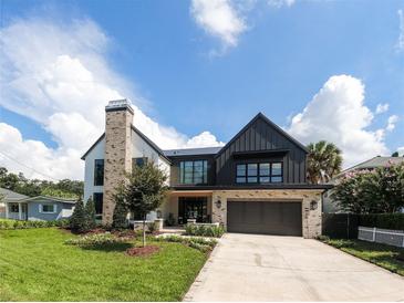 Modern farmhouse with two-car garage and landscaped lawn at 3305 W Beaumont St, Tampa, FL 33611