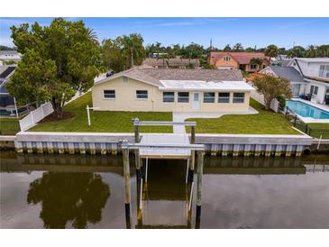 Aerial view of a single-story home with a private dock and canal access at 8716 Elmwood Ln, Tampa, FL 33615