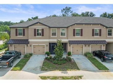 Three townhouses with garages and landscaping at 8491 Essington St, New Port Richey, FL 34654