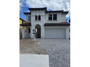 Elegant two-story home featuring a tile roof, arched entryway, and a spacious two-car garage at 320 W Park Ave, Tampa, FL 33602
