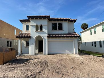 Mediterranean-style home featuring a stucco exterior, arched entryway, and a two-car garage at 320 W Park Ave, Tampa, FL 33602