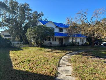 Two-story home with a blue tarp roof, front-facing porch, and walkway at 905 John Hunter Ct, Brandon, FL 33511