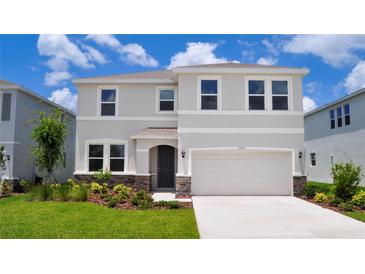 Two-story home with neutral-colored stucco, a two-car garage, well-maintained landscaping and a paver walkway to the front door at 16013 7Th E Ave, Bradenton, FL 34212