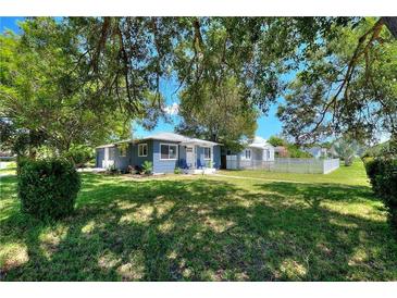 Charming single-story home with a lush green lawn and mature trees providing shade at 3763 Dartmouth N Ave, St Petersburg, FL 33713