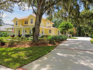 Charming yellow two-story home with a landscaped yard and a long, spacious driveway at 6527 Stonington Dr, Tampa, FL 33647