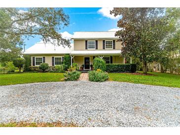 Two-story home with metal roof and landscaped yard at 29249 Wilpayne Rd, Brooksville, FL 34602