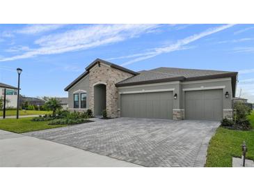 Two-story house with three-car garage and herringbone driveway at 9120 Warm Springs Cir, Parrish, FL 34219