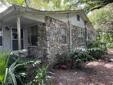 Cozy cottage with stone exterior and mature landscaping at 8707 127Th Ave, Tampa, FL 33637