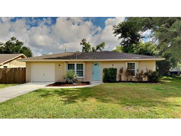 Single story home with a light beige exterior and teal door at 1154 Barbour Ave, Port Charlotte, FL 33948