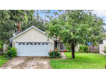 Charming yellow house with a two-car garage and well-maintained lawn at 5001 80Th Avenue E Cir, Sarasota, FL 34243