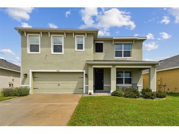 Two-story house with a two-car garage and landscaped yard at 35533 Stella Vast Dr, Zephyrhills, FL 33541