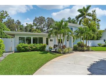 Charming light blue house with lush landscaping at 608 Armada S Rd, Venice, FL 34285