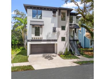 Modern three-story home boasts a two-car garage and a sleek staircase to the front door at 321 W Hanlon St, Tampa, FL 33604