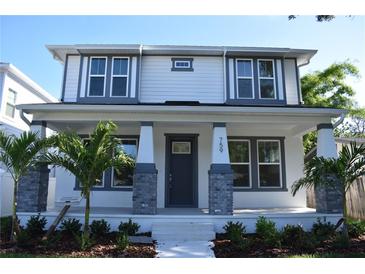 Charming two-story home featuring a welcoming front porch with decorative columns and lush landscaping at 759 48Th N Ave, St Petersburg, FL 33703