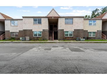 Exterior view of a two-story apartment building with brick and stucco at 9009 Westchester Cir # B-18, Tampa, FL 33604