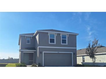 Two-story house with gray siding, two-car garage, and a landscaped yard at 10812 Hidden Banks Gln, Parrish, FL 34219