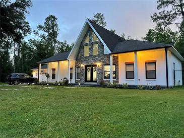 A-frame style home with a stone facade and charming front yard at 26638 Green Willow Run, Wesley Chapel, FL 33544
