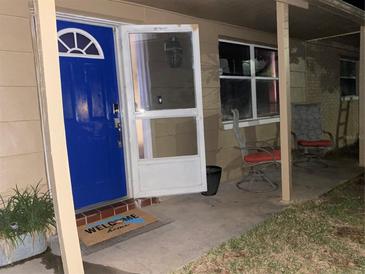 Inviting front porch with blue door and welcoming mat at 6115 7Th Ave, New Port Richey, FL 34653