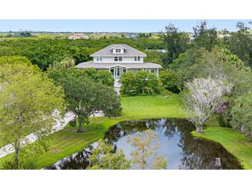 Charming two-story home with pond and lush landscaping at 1215 Bayshore Dr, Terra Ceia, FL 34250