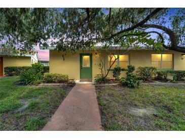 Yellow condo building with green door entrance at 401 Dorchester Pl # 58, Sun City Center, FL 33573