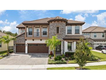 Two-story home with stone accents and a three-car garage at 13029 Paddock Wood Pl, Riverview, FL 33579