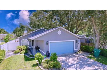 Charming single-story home features a blue garage door, manicured lawn, and cozy porch at 4477 67Th N St, St Petersburg, FL 33709