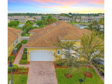 Charming yellow home with a tile roof, brick driveway, and attached two car garage at 4737 Casswell Dr, New Port Richey, FL 34652