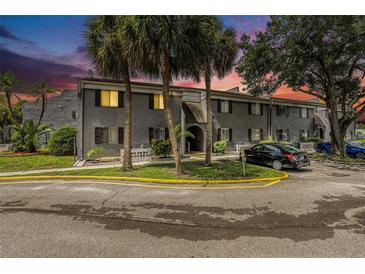 Gray condo building with parking and landscaping at dusk at 3822 Cortez Dr # D, Tampa, FL 33614