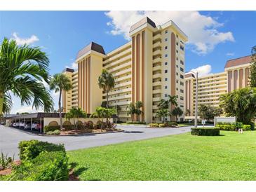 Attractive multi-story condo building featuring multiple balconies, manicured landscaping, and convenient covered parking at 4550 Cove Cir # 501, St Petersburg, FL 33708