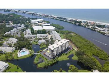 Aerial view of a condo building in a waterfront community with a pool and surrounding buildings at 11590 Shipwatch Dr # 548, Largo, FL 33774