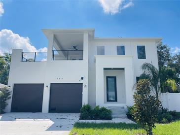 Two-story modern home with dark brown garage doors and a balcony at 4604 W Euclid Ave, Tampa, FL 33629