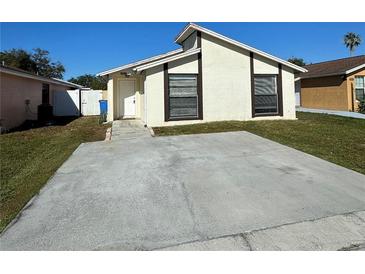 Front view of a single-story house with a paved driveway and small front yard at 9209 Dalwood Ct, Tampa, FL 33615