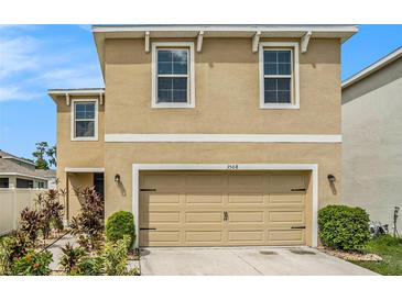 Tan two-story house with a two-car garage and landscaping at 3508 Diamond Leaf Ct, Valrico, FL 33594