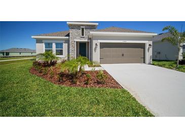 Charming single-story home featuring a well-manicured lawn, tasteful landscaping, and a neutral color scheme at 11963 Richmond Trl, Parrish, FL 34219