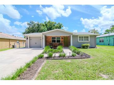 Charming renovated home with a landscaped front yard and attached garage at 9717 N Rome Ave, Tampa, FL 33612