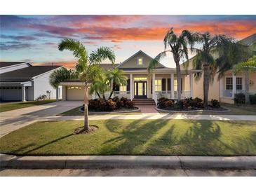 Charming two-story house with a front porch and palm trees at 528 Islebay Dr, Apollo Beach, FL 33572
