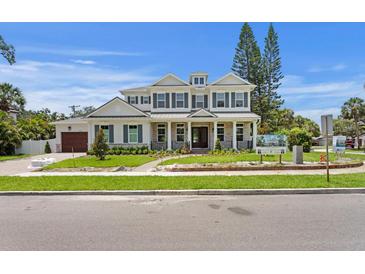 Beautiful two-story home featuring white brick, a covered porch with columns, and lush landscaping at 4536 W Swann Ave, Tampa, FL 33629