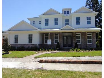 Charming two-story home featuring a brick-accented facade, a well-manicured lawn, and an inviting entrance at 4536 W Swann Ave, Tampa, FL 33629