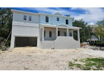 Newly constructed two-story home featuring white brick and siding under a cloudy blue sky at 610 Ontario Ave, Tampa, FL 33606