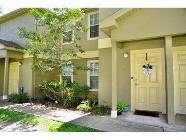 Tan two-story townhome with a light beige door at 36121 Lake Chase Blvd # 204, Zephyrhills, FL 33541