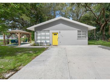 Mid-century modern home with yellow door and gazebo at 1334 Fairmont St, Clearwater, FL 33755