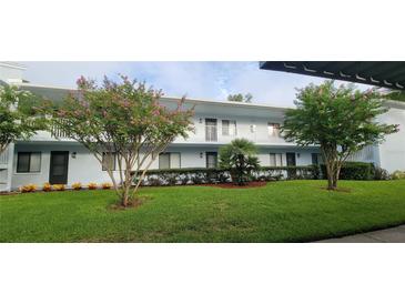 Exterior view of a light blue condo building with lush landscaping at 312 Martha Ln # 312, Oldsmar, FL 34677