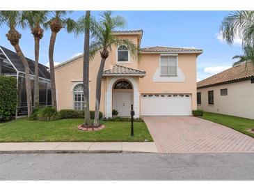 Two-story home with a peach-colored exterior and a brick driveway at 10713 Cape Hatteras Dr, Tampa, FL 33615