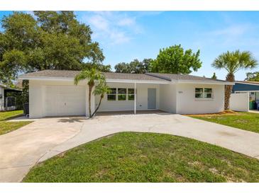 Updated single story home with fresh white exterior, and a grassy front yard at 7571 Ridge Rd, Seminole, FL 33772