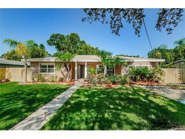 Attractive ranch home with landscaped lawn and walkway at 705 Bayshore Dr, Tarpon Springs, FL 34689