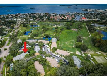 Stunning aerial view of community with lush landscaping, golf course, and water views at 2156 Masters Ct # 2156, Dunedin, FL 34698