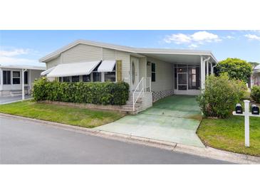 Charming home with a covered carport, mature landscaping, and decorative window awnings at 12501 Ulmerton Rd # 131, Largo, FL 33774