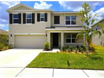 Charming two-story home featuring a well-manicured lawn, attached two-car garage, and a welcoming front porch at 8367 Ender Hills Dr, Wesley Chapel, FL 33545