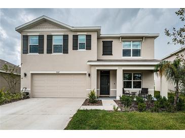 Two-story house with a tan exterior and dark shutters at 8367 Ender Hills Dr, Wesley Chapel, FL 33545